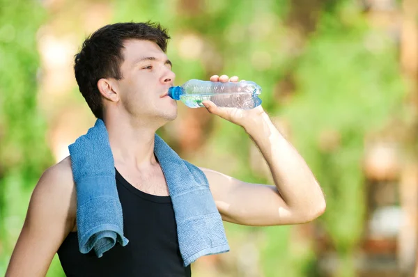 Muž pitné vody po fitness — Stock fotografie