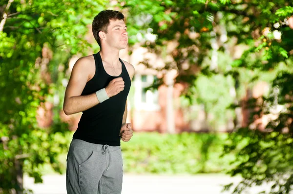 Młody człowiek jogging w parku — Zdjęcie stockowe