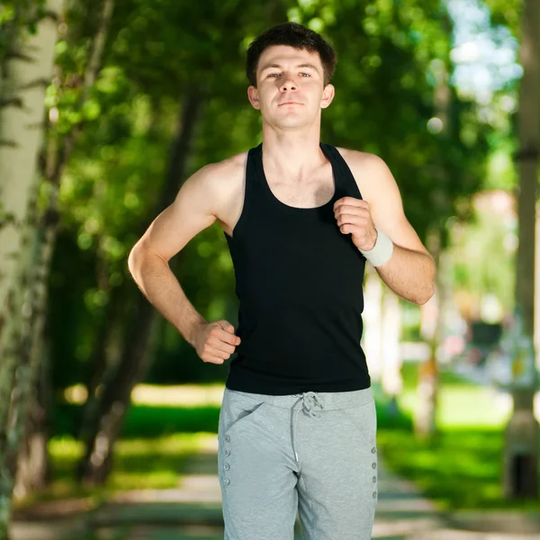 Jeune homme jogging dans le parc — Photo