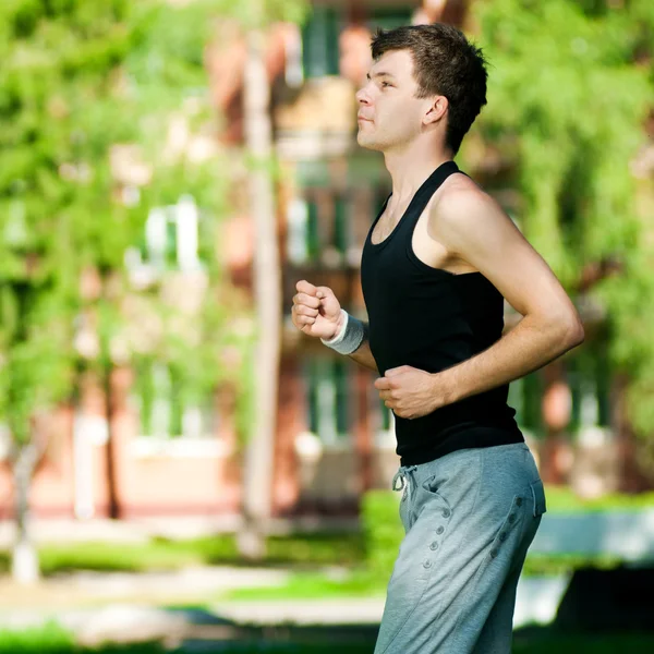 Jonge man joggen in het park — Stockfoto