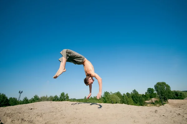 Opgewonden jonge man springen in de lucht — Stockfoto