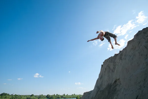 Podekscytowany młody człowiek skoki w powietrzu — Zdjęcie stockowe