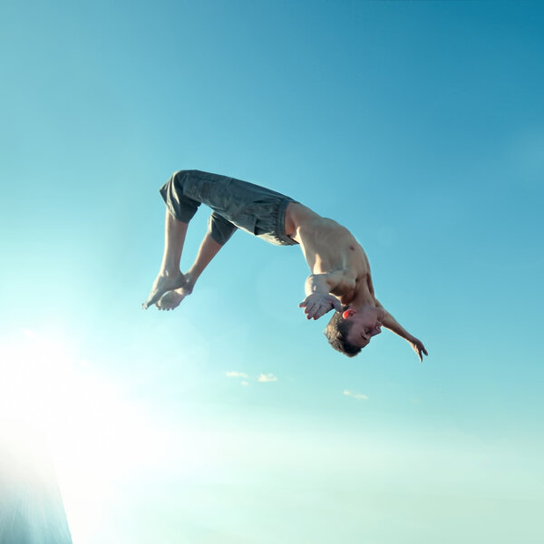 Возбужденный молодой человек, прыгающий в воздух
