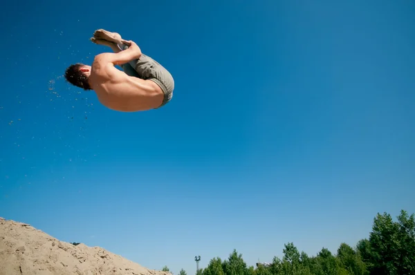 Opgewonden jonge man springen in de lucht — Stockfoto