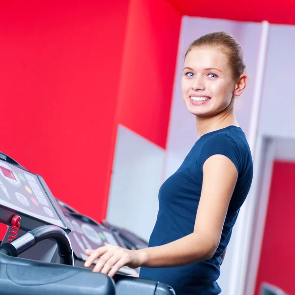Молодая женщина в спортзале работает на автоответчике — стоковое фото