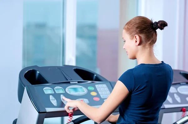 Giovane donna in palestra correre su una macchina — Foto Stock