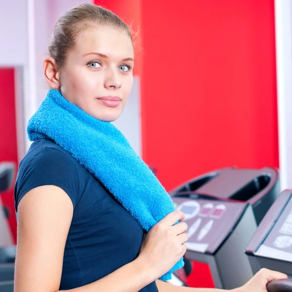 Spor salonunda bir makinede çalışan genç bir kadın — Stok fotoğraf