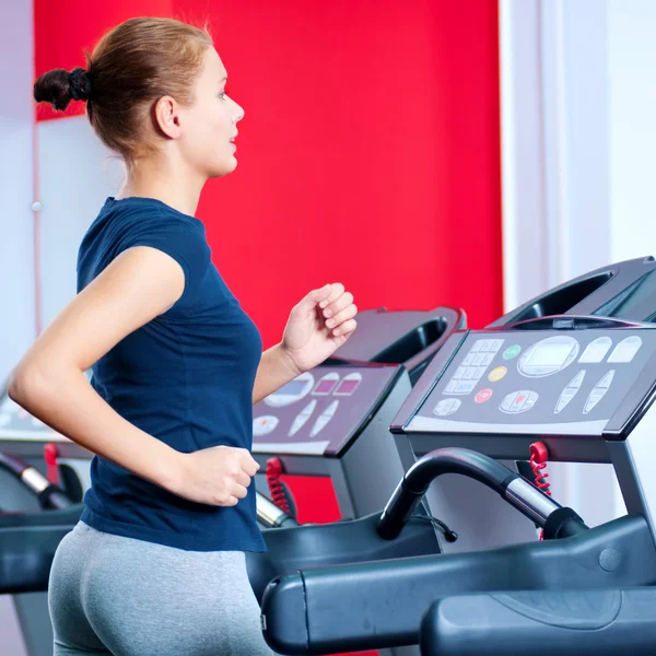 Jovem mulher no ginásio correr em uma máquina — Fotografia de Stock