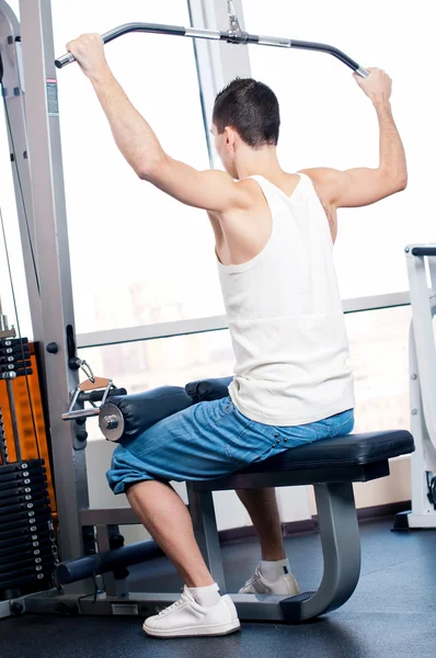 Young man doing exercises at gym — Stock Photo, Image