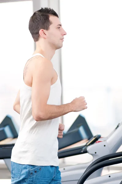 Hombre en el gimnasio haciendo ejercicio. Corre. . —  Fotos de Stock