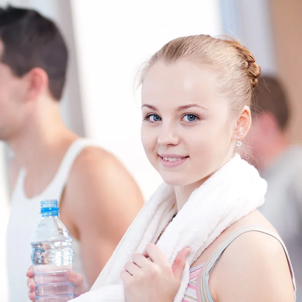 Man and woman drinking water after sports in gym — Stock Photo, Image