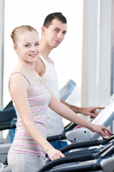 Mujer en el gimnasio haciendo ejercicio. Ejecutar en máquina —  Fotos de Stock