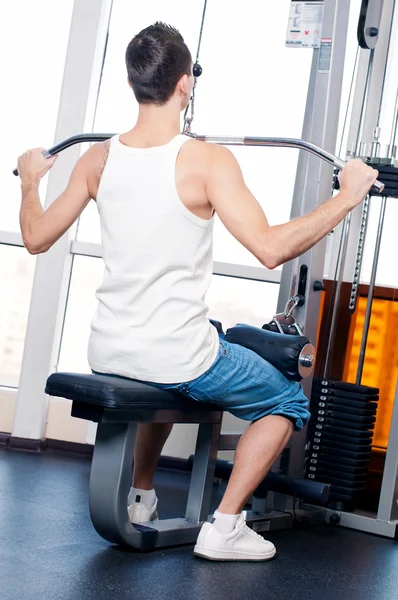 Young man doing exercises at gym — Stock Photo, Image