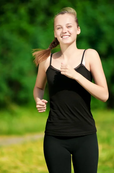 Junge Frau läuft in grünen Park — Stockfoto