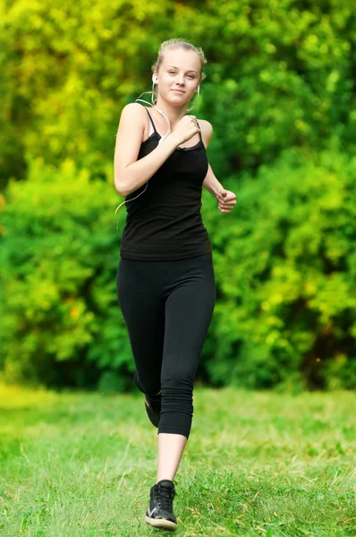 Mujer joven corriendo en el parque verde — Foto de Stock