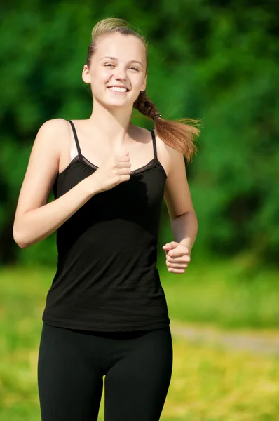 Junge Frau läuft in grünen Park — Stockfoto