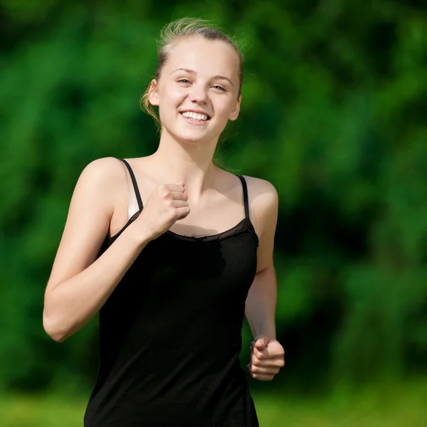 Mujer joven corriendo en el parque verde — Foto de Stock