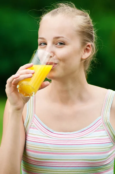 Junge Frau trinkt Orangensaft. Außenbereich — Stockfoto