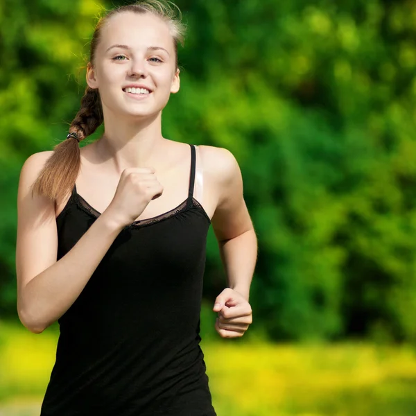 Young woman running in green park — Stock Photo, Image