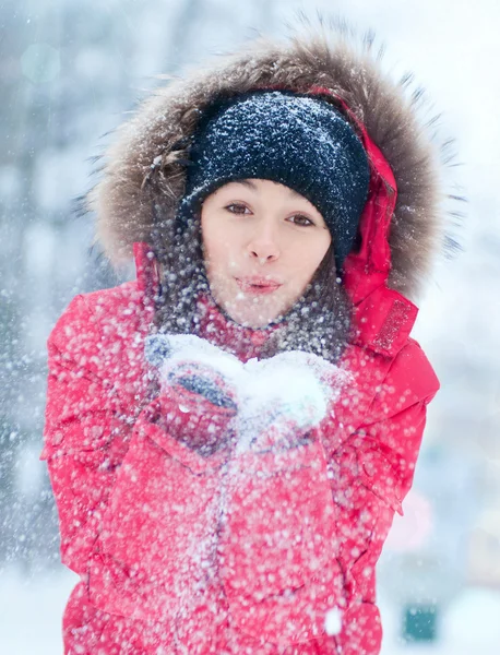 Glückliche junge Frau spielt mit einem Schnee lizenzfreie Stockfotos