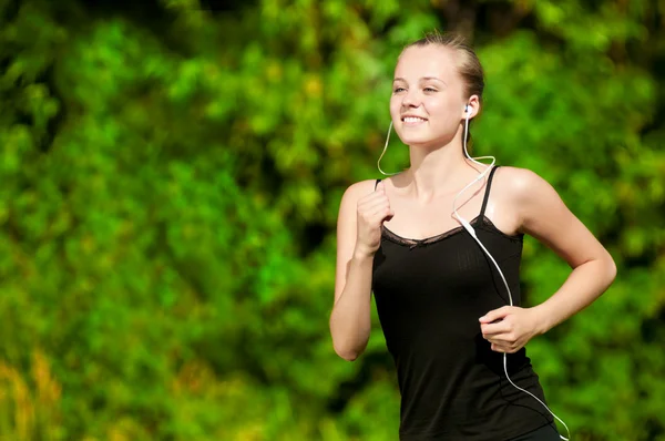 Young woman running in green park Royalty Free Stock Images