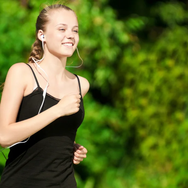 Young woman running in green park Stock Photo