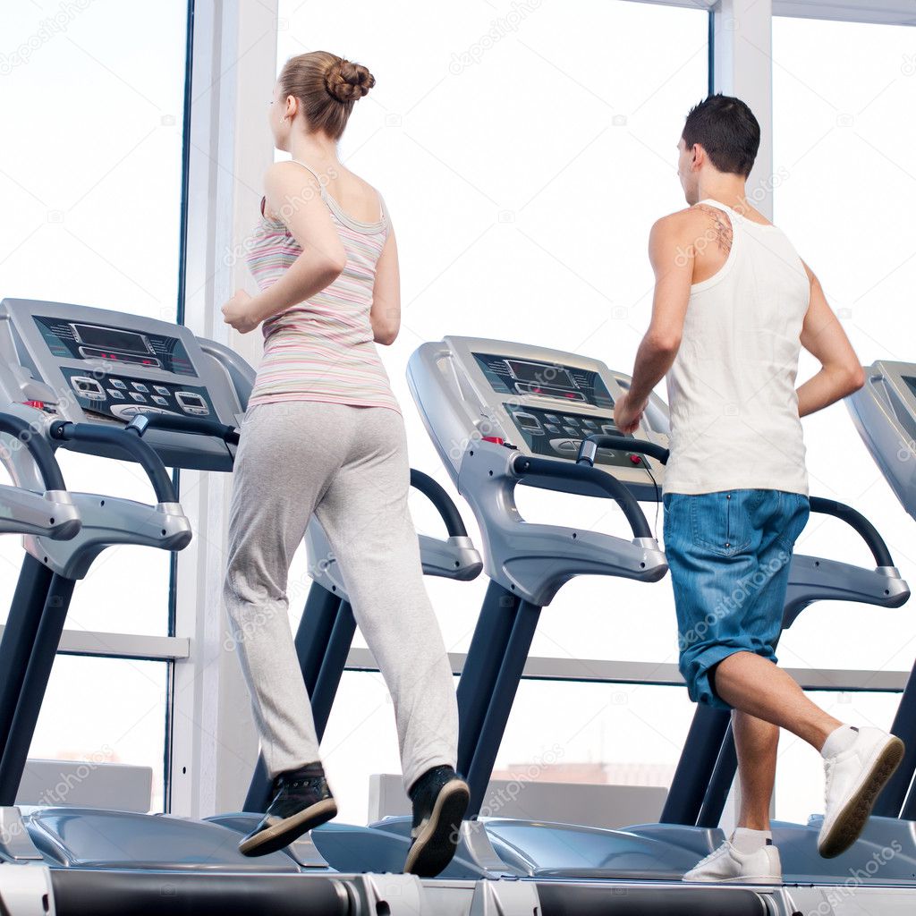 Woman and man at the gym exercising.