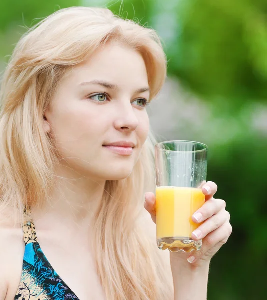 Lächelnde Frau trinkt Orangensaft — Stockfoto