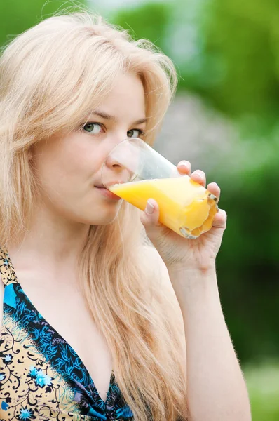 Smiling woman drinking orange juice — Stock Photo, Image