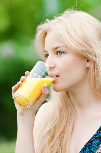 Donna sorridente bere succo d'arancia — Foto Stock