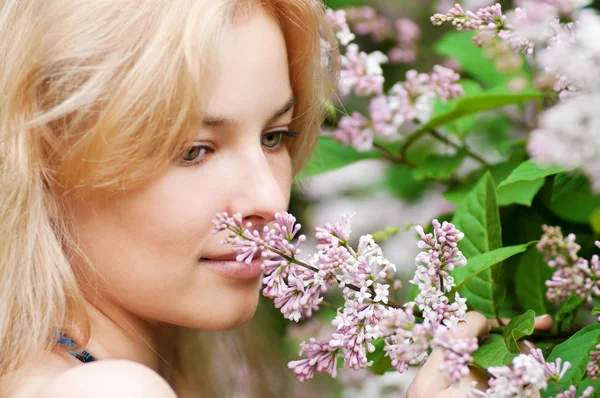 顔にライラックの花を持つ女性 — ストック写真