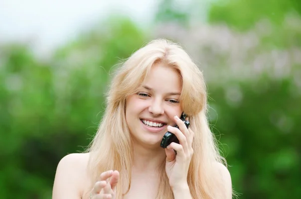 Giovane donna che utilizza il telefono al parco — Foto Stock