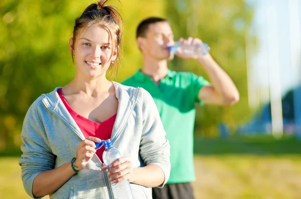 Man en vrouw drinken uit de fles — Stockfoto