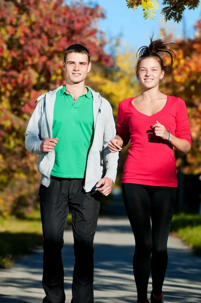 Joven hombre y mujer corriendo — Foto de Stock