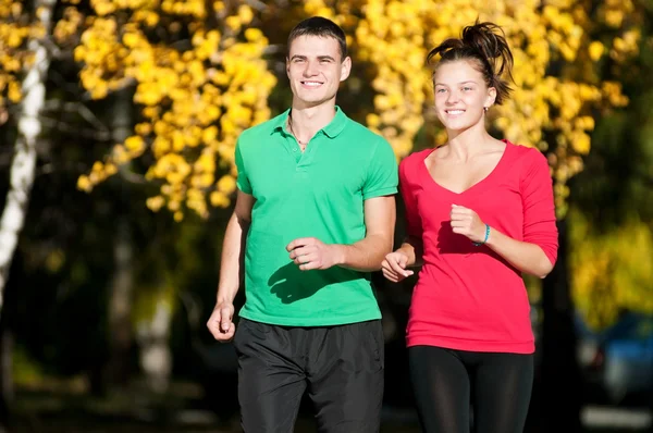 Joven hombre y mujer corriendo — Foto de Stock