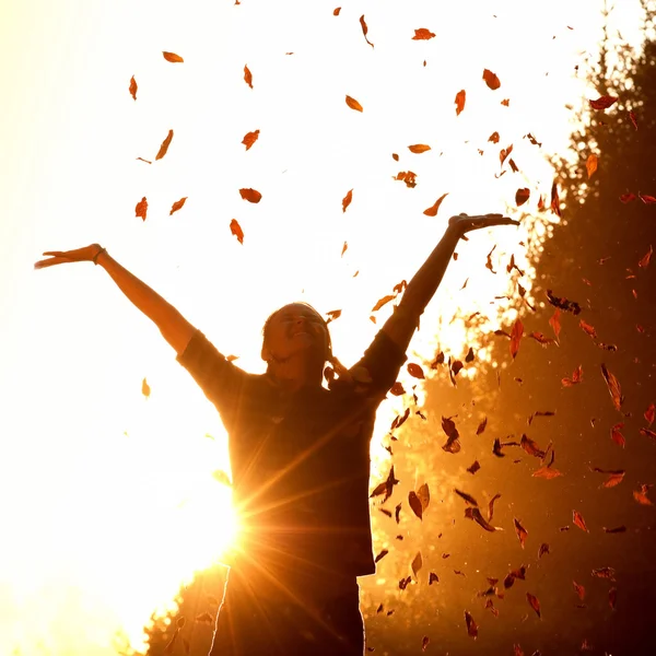 sonbahar yaprakları ile oynayan kadın