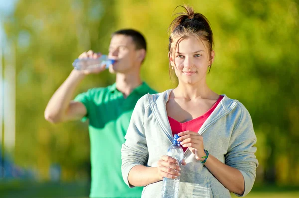 Man and woman drinking from bottle — Stock Photo, Image