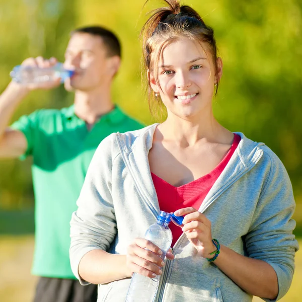 Man and woman drinking from bottle — Stock Photo, Image