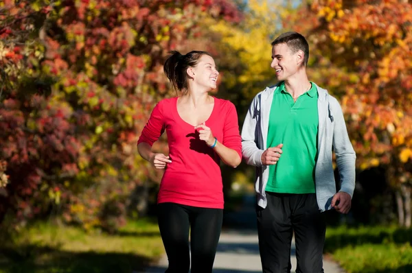 Joven hombre y mujer corriendo — Foto de Stock