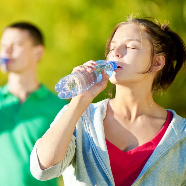 Man and woman drinking from bottle — Stock Photo, Image