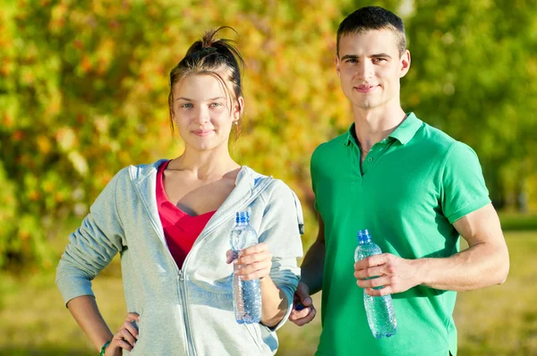 Mann und Frau trinken aus Flasche — Stockfoto