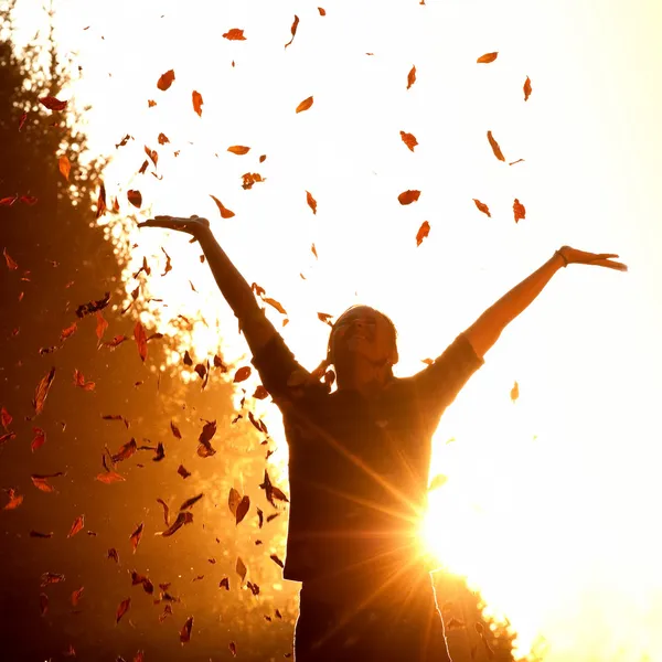 Frau spielt mit Herbstblättern — Stockfoto