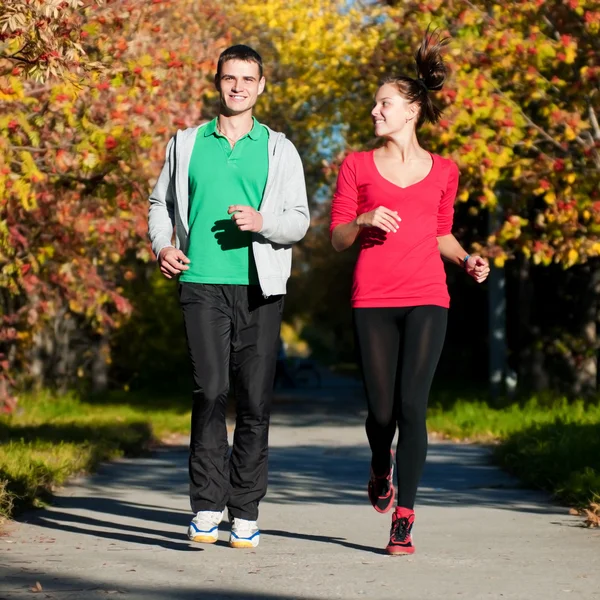 Joven hombre y mujer corriendo — Foto de Stock