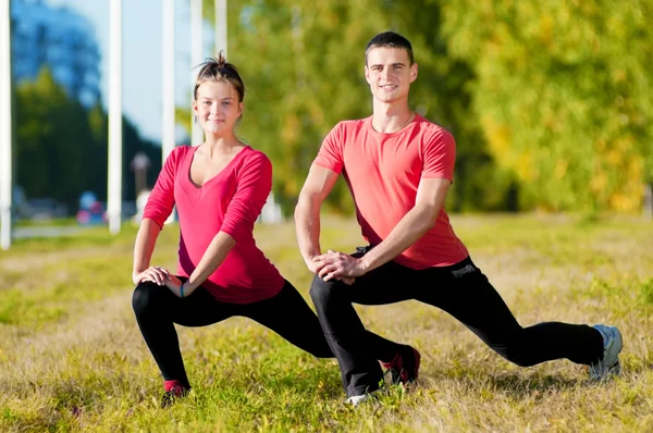 Mann und Frau beim Yoga im Park — Stockfoto