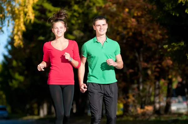 Joven hombre y mujer corriendo — Foto de Stock