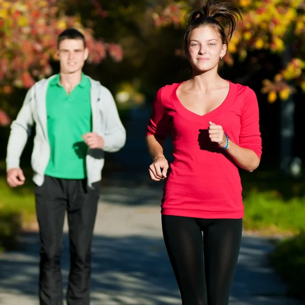 Jovem e mulher correndo — Fotografia de Stock