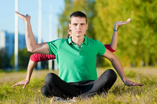 Uomo e donna che fanno yoga nel parco — Foto Stock