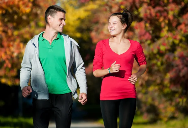 Joven hombre y mujer corriendo — Foto de Stock