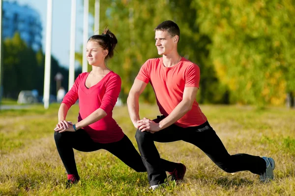 Mann und Frau beim Yoga im Park — Stockfoto