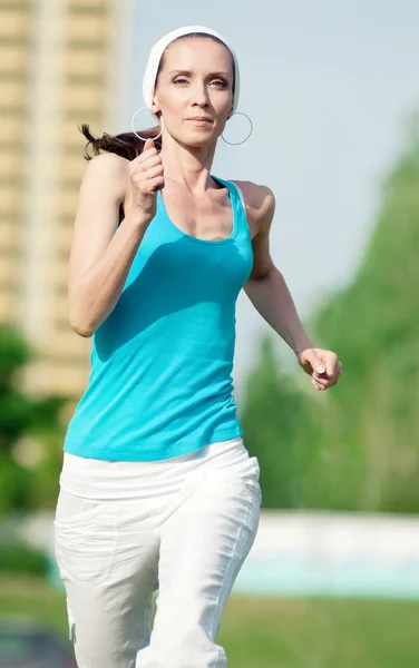 Mooie vrouw uitgevoerd in groen park — Stockfoto